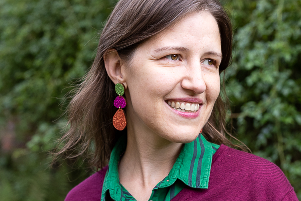 Personal branding portrait of a woman with brown hair, smiling softly and looking into the distance.