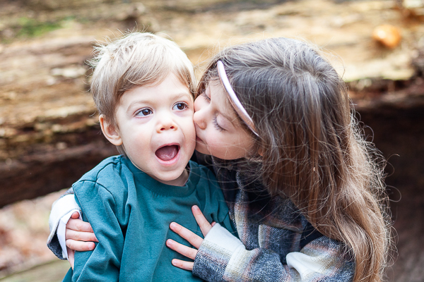 siblings interacting naturally during outdoor family photoshoot wearing casual outfits UK
