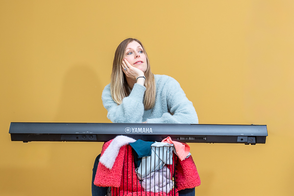 Business owner leaning on keyboard during branding photoshoot illustrating creative branding photo ideas for small business