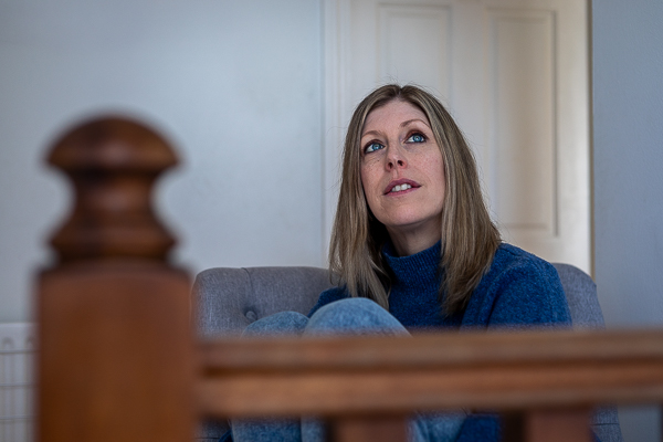 Contemplative branding portrait of coach Jo Allen sitting thoughtfully indoors during a personal branding session in Hampshire