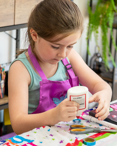 Child concentrating on an arts and crafts activity during a relaxed family photography session in Fleet, Hampshire.