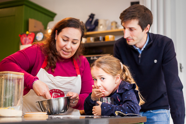 Parents and daughter baking together in the kitchen during an at-home family photoshoot in Hampshire